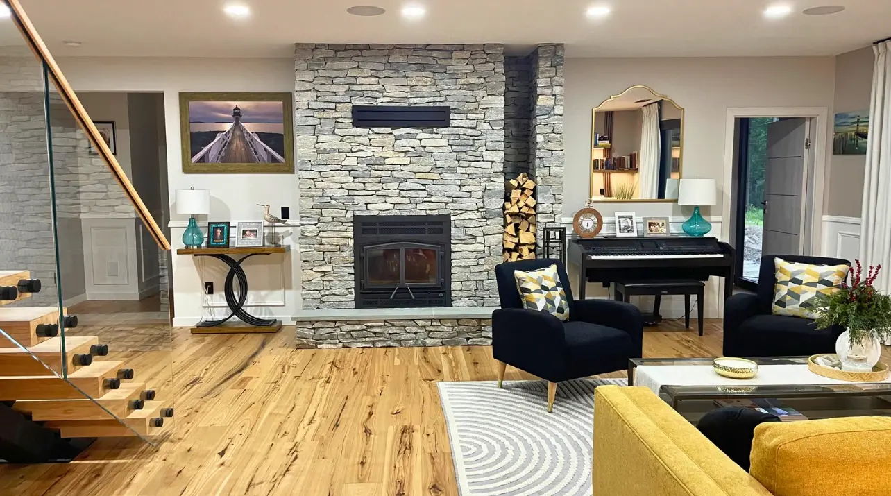 Living room with a full-height stacked stone fireplace and exposed beam
