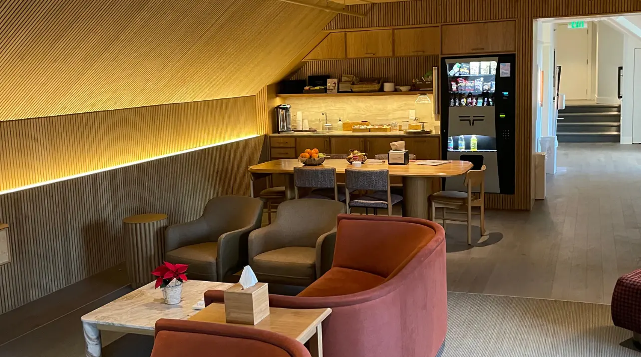 Lounge with amber cove lighting, wood-slat ceiling and built-in bar