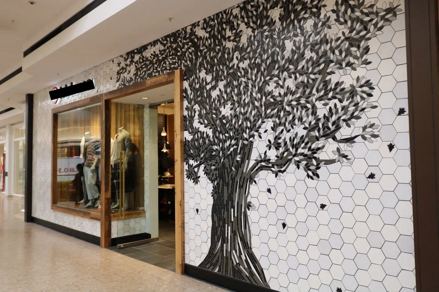 Commercial retail interior with a sculptural tree feature wall and hexagon tile