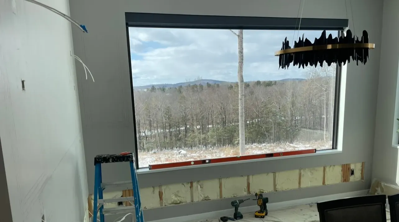 Room with a large picture window framing the Litchfield County treeline