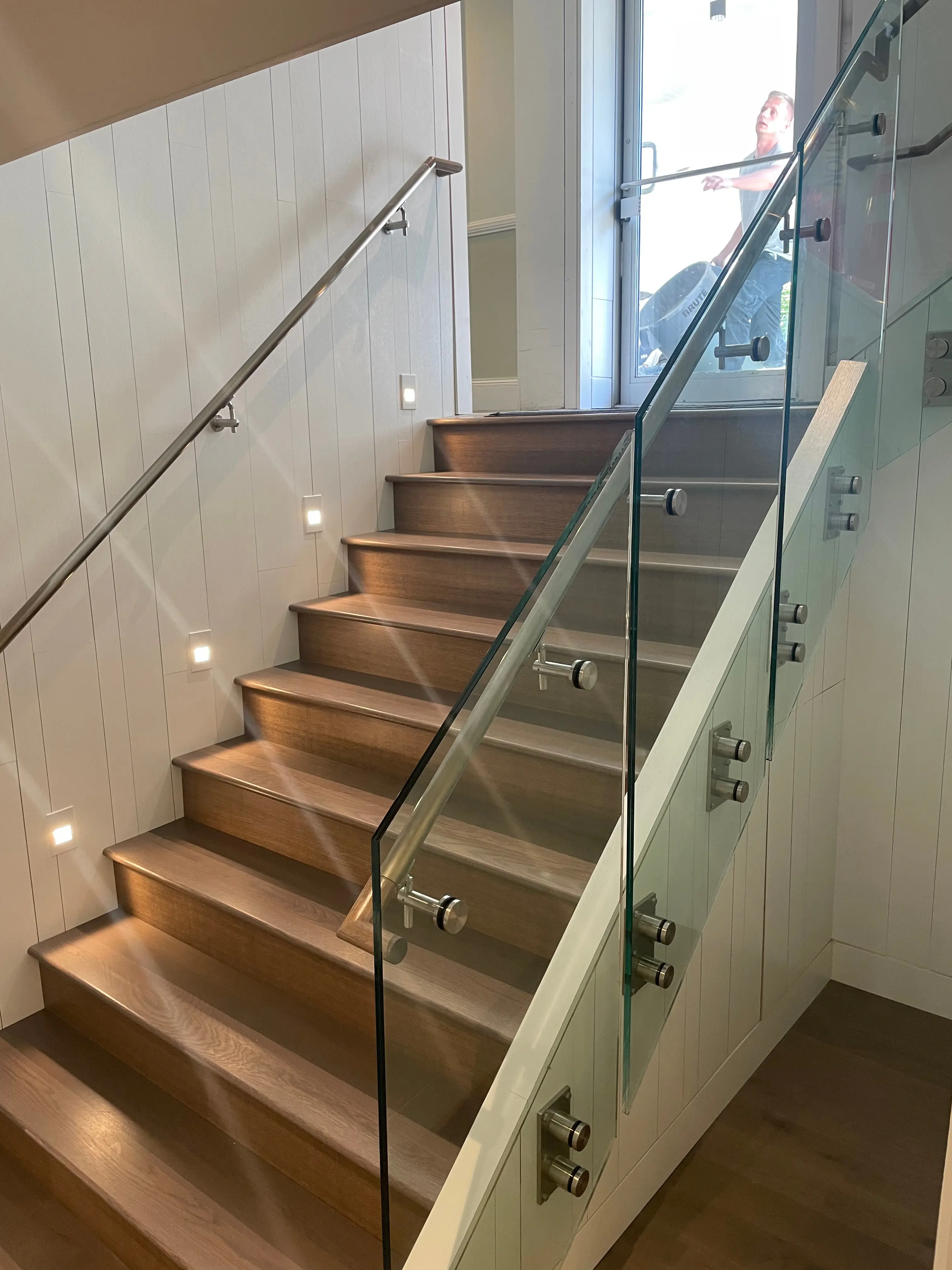 Open staircase with wood treads and a frameless glass balustrade